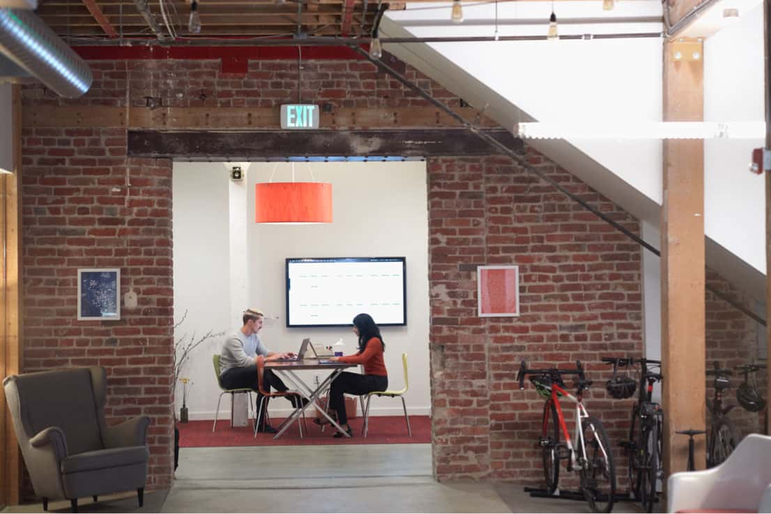 two employees working in corner of office