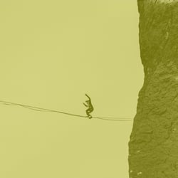 Person walking on tightrope between mountains