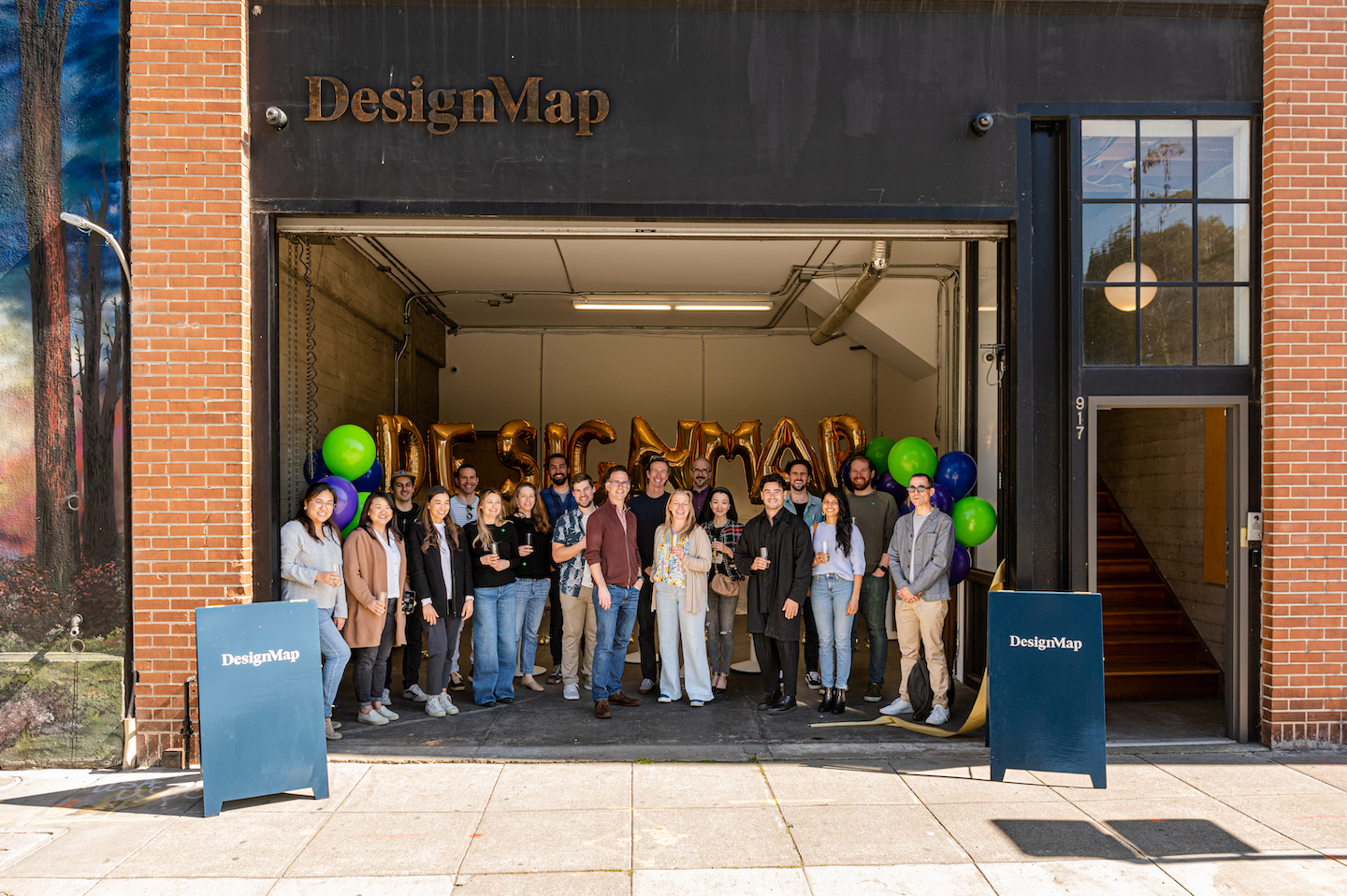 DesignMap team stands together at the front of the new office.